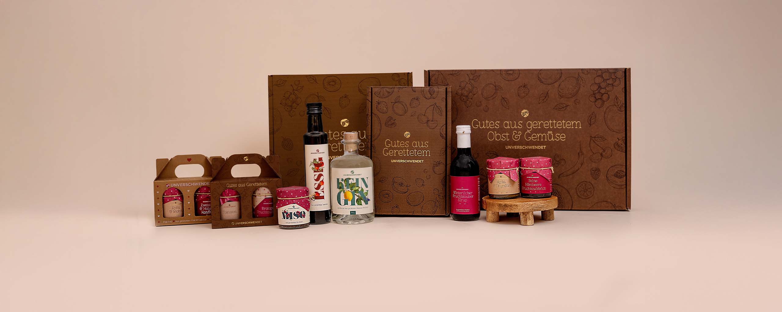 Geschenkkartons von Unverschwendet mit Inhalt vor den Kartons (Vorderansicht) Geschenkkartons von Unverschwendet mit Inhalt vor den Kartons