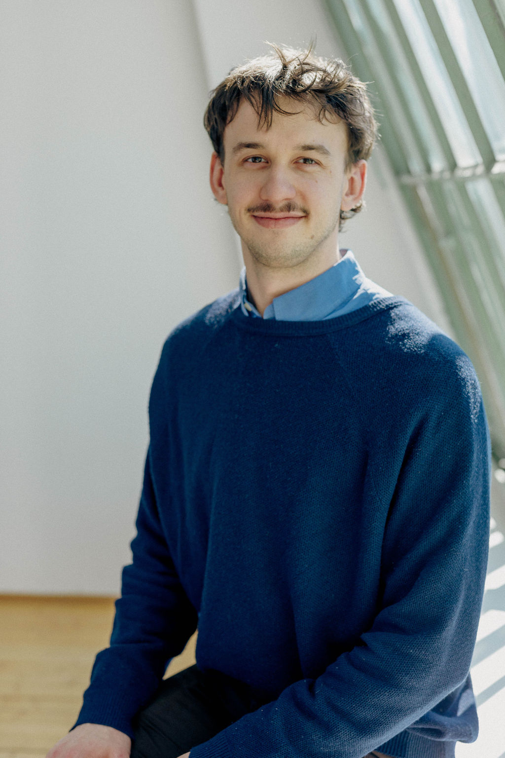 Mann mit Schnurrbart lächelt in die Kamera (Florian Ruckenbauer) Mann mit Schnurrbart lächelt in die Kamera
