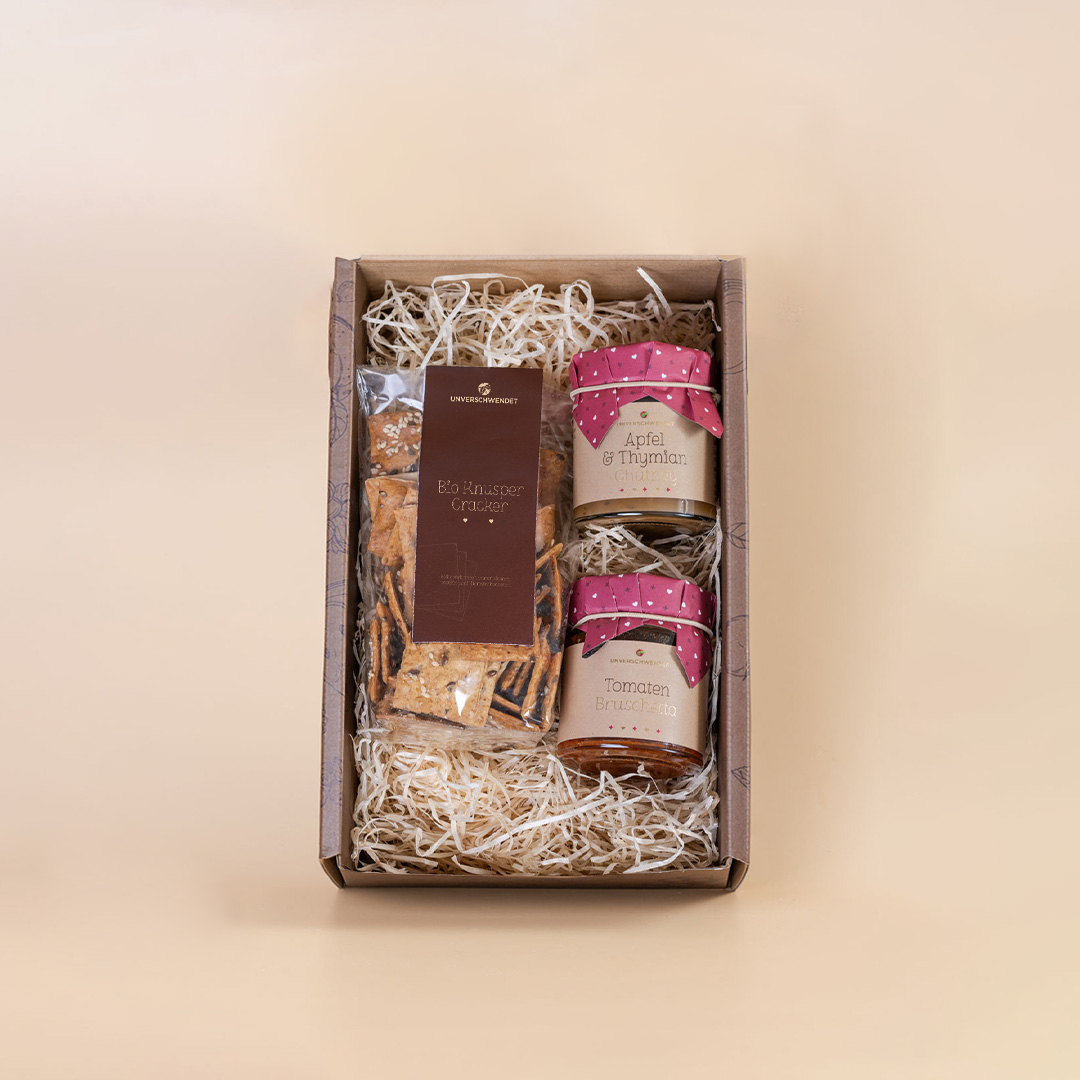 Geöffnete Geschenkbox mit Aufstrich-Gläschen und Crackern (von oben) Geöffnete Geschenkbox mit Aufstrich-Gläschen und Crackern