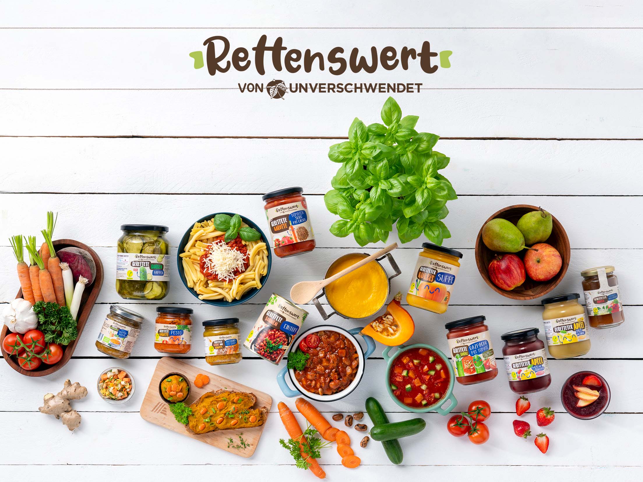 Gerettete Lebensmittel und daraus entstandene Gerichte auf einem Tisch - Ansicht von Oben Gerettete Lebensmittel auf einem Tisch verteilt, zusammen mit Gerichten, welche aus diesen Lebensmitteln entstehen können