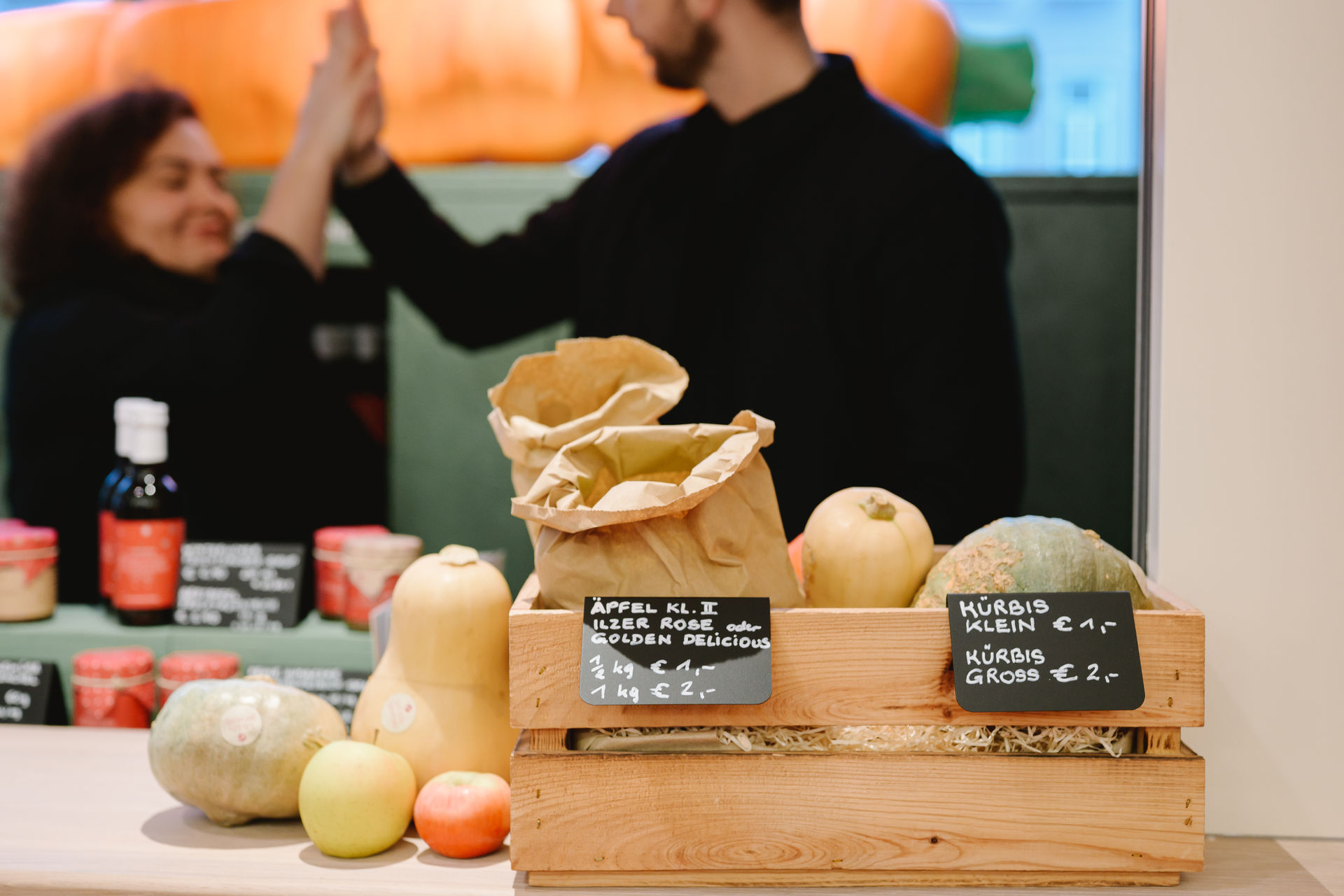 gerettete Äpfel und Kürbisse zum Verkauf in Holzkiste (Nahaufnahme) gerettete Äpfel und Kürbisse zum Verkauf in Holzkiste