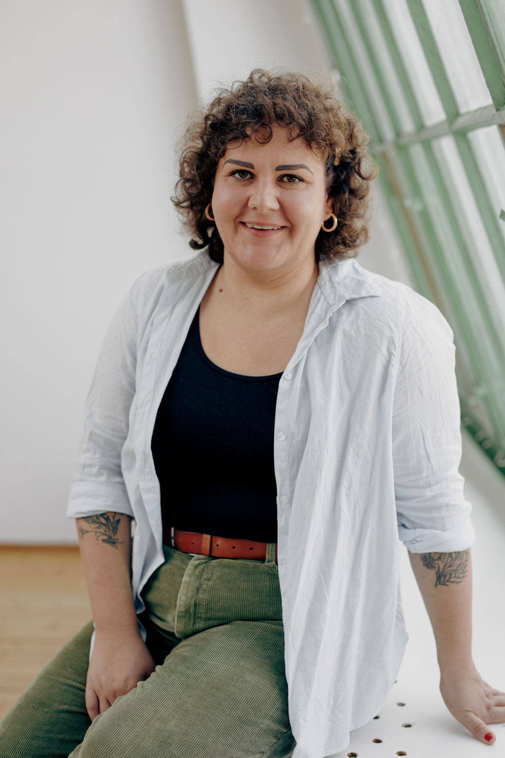 Frau mit Locken lächelt in die Kamera(Rita Buchacher) Frau mit Locken lächelt in die Kamera