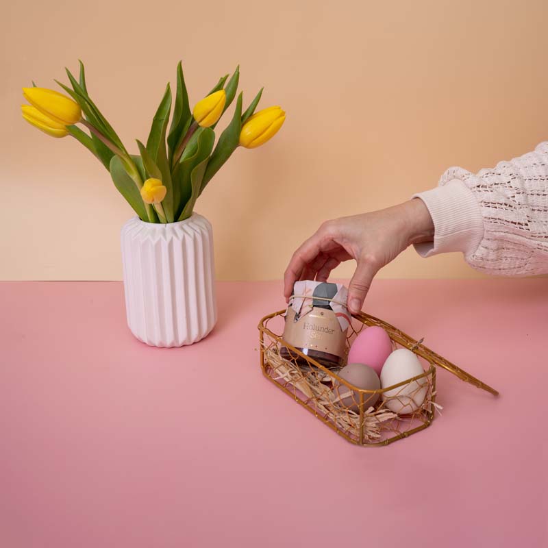 Unverschwendet-Aufstrich im Osterkorb auf rosanem Tisch mit Blumenstrauß Unverschwendet-Aufstrich im Osterkorb